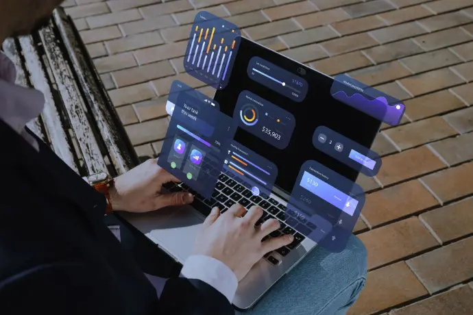 Person using a laptop to view digital dashboard showing business performance and data reporting